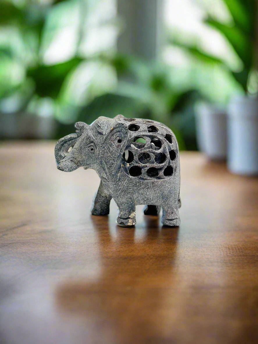 Cairo hand-carved stone elephant figurine on wood surface, luxury decor accent