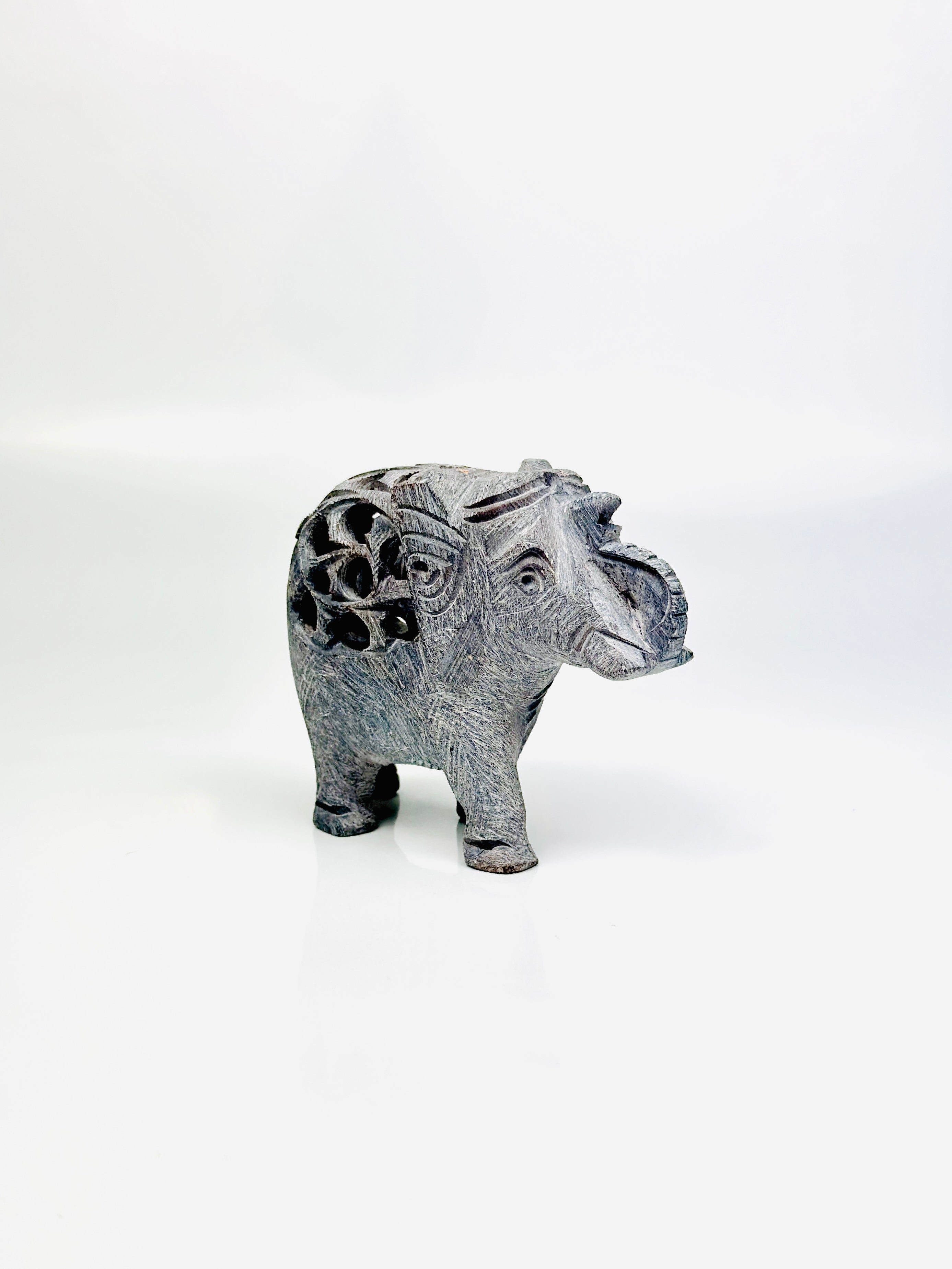 Side view of Cairo hand-carved elephant figurine on white background